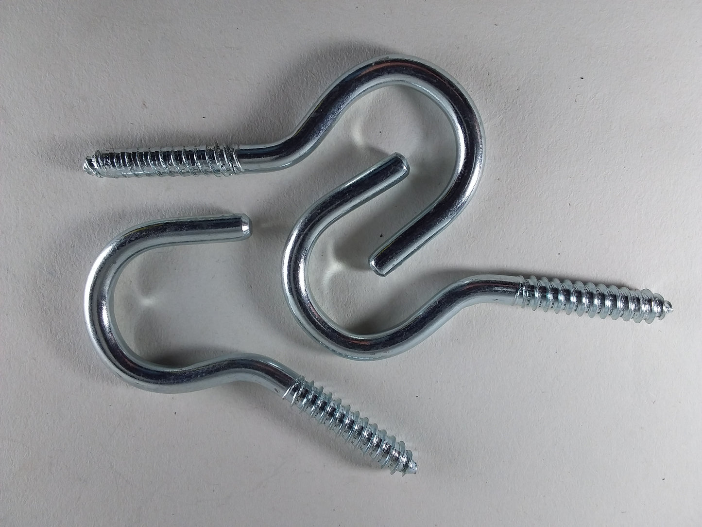 Two 100mm steel screw hooks with screws visible