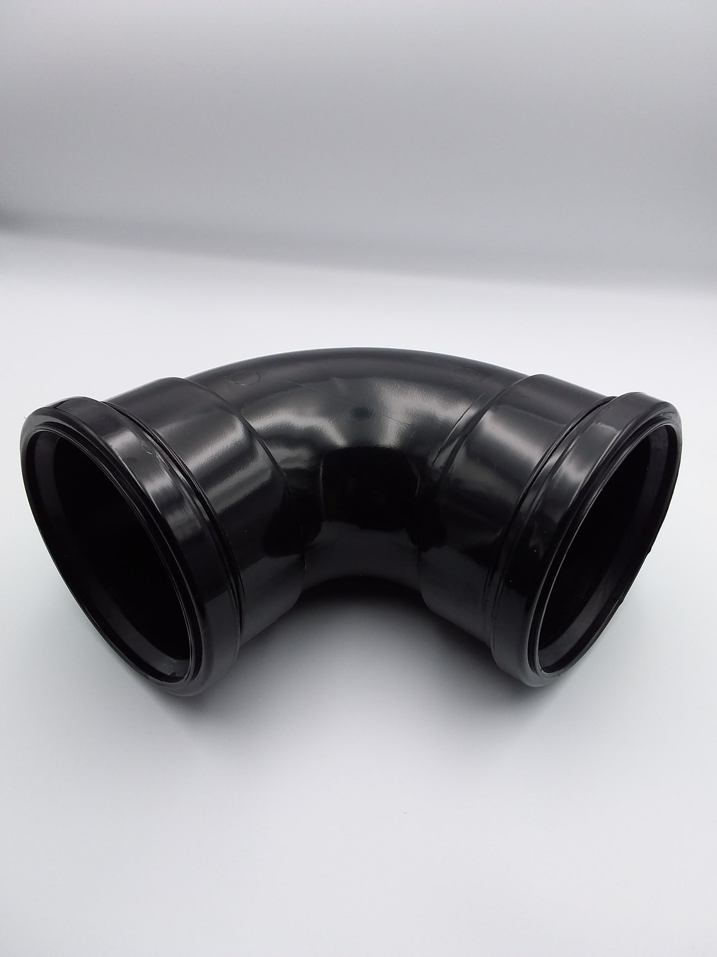 110mm black 90-degree elbow ducting bend made of plastic.