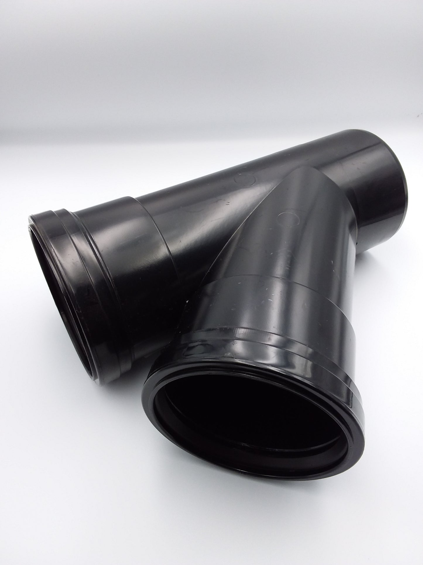 A black 110mm double socket 45deg push fit tee plumbing fitting.