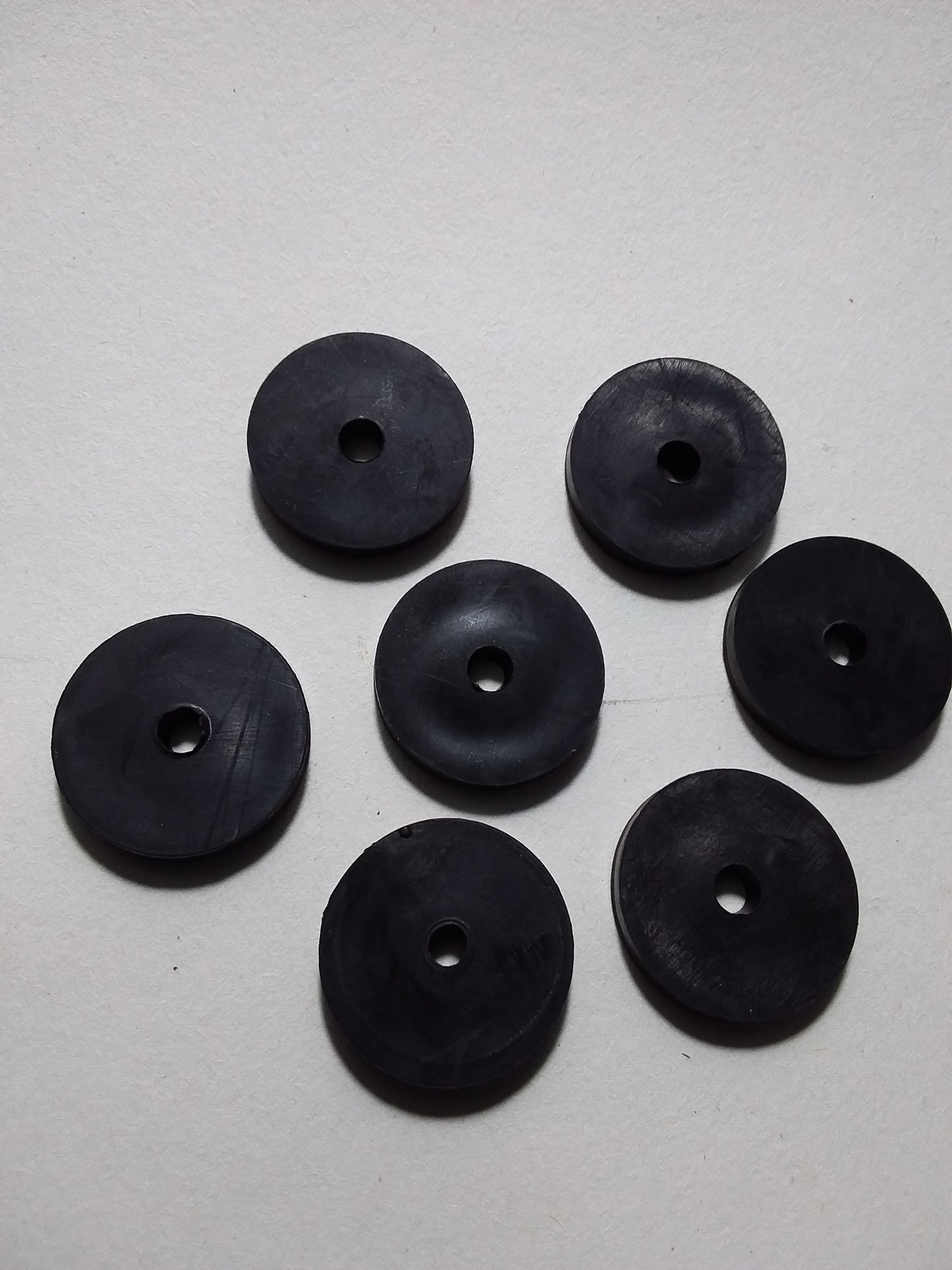 1/2" black rubber tap washers arranged on a surface.