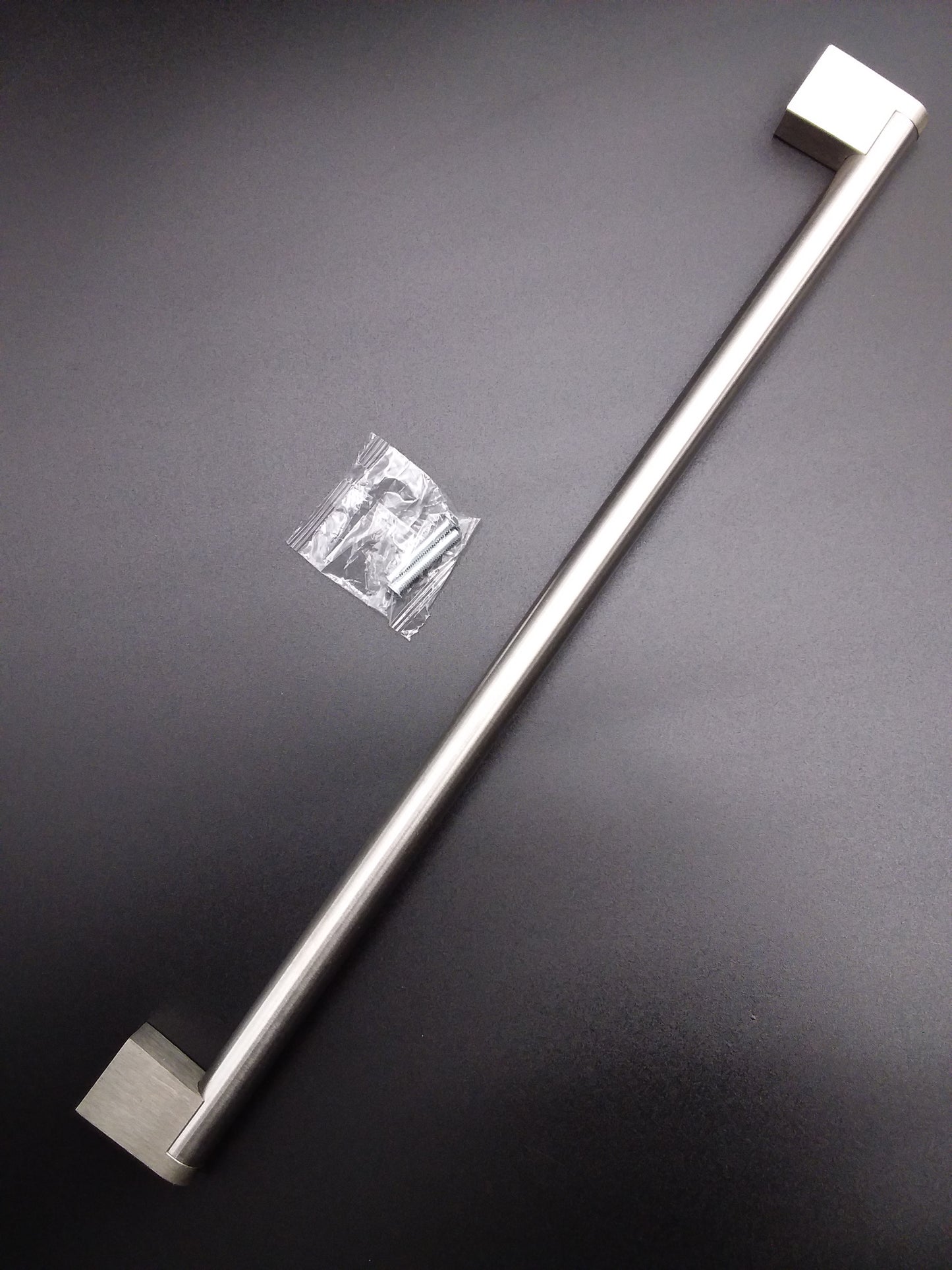 A stainless steel tubular bar handle for a door.