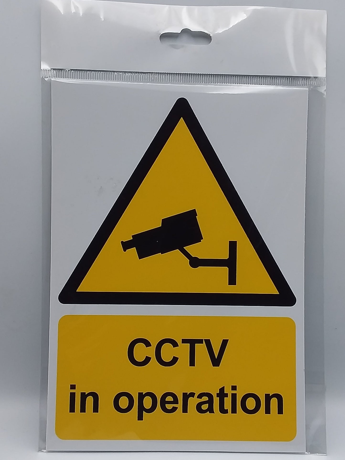 A self-adhesive sign with a yellow warning triangle and a CCTV camera icon, stating 'CCTV in operation'.