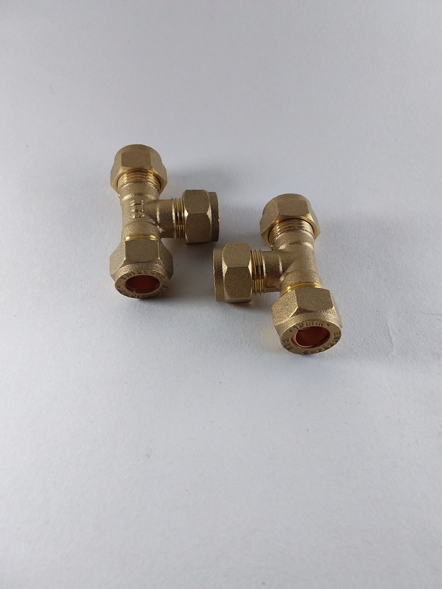 Brass compression equal tee plumbing fitting with three connections.