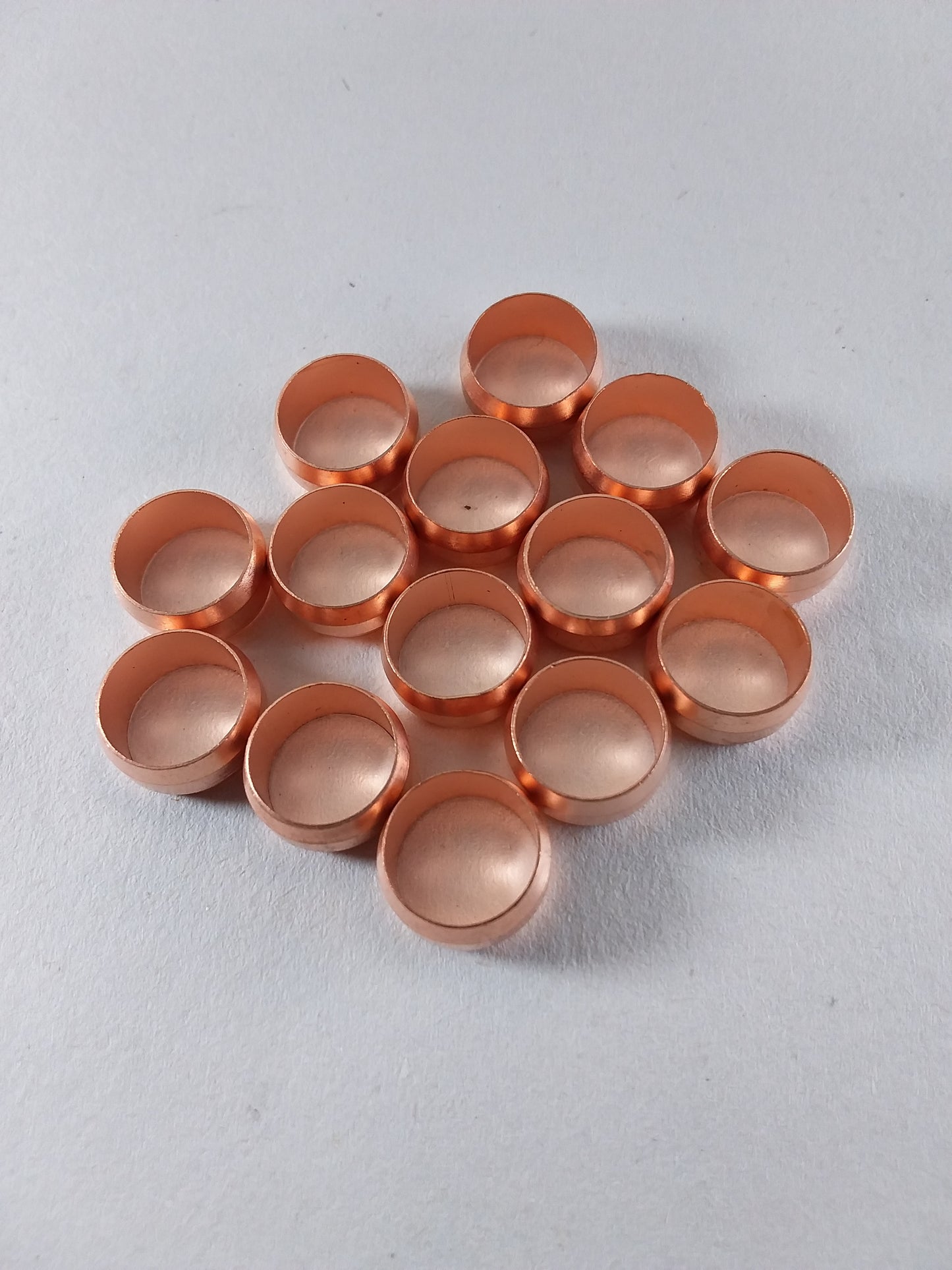 Copper colored olive shaped plumbing fittings.