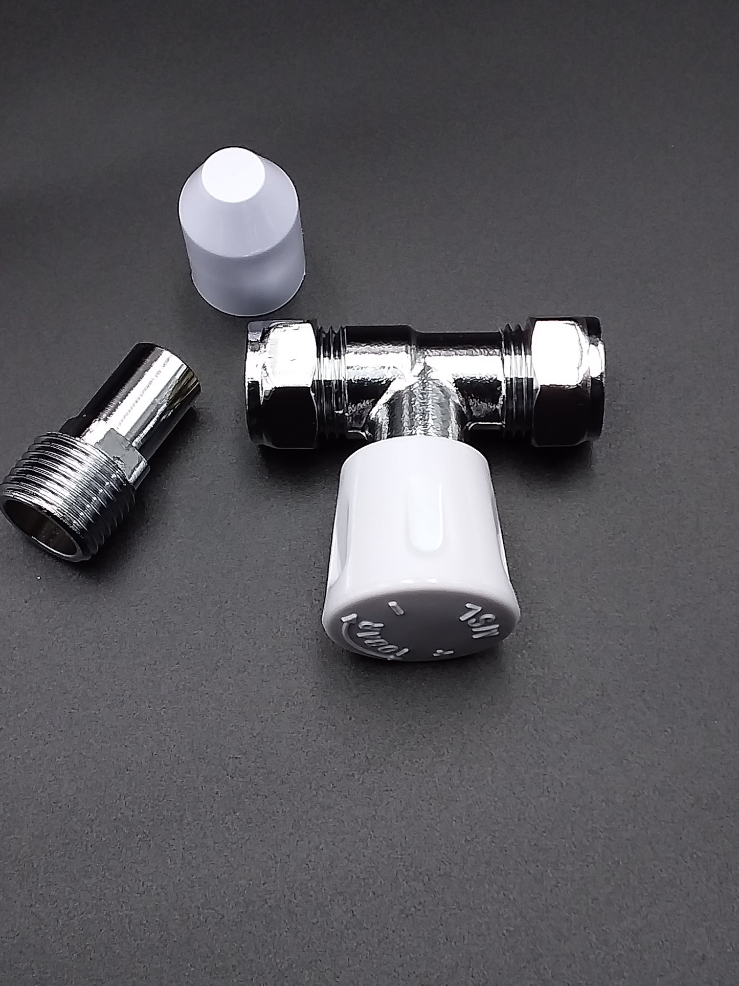 A 15mm L/S radiator valve with a straight design, featuring a metallic body and a white plastic handle.