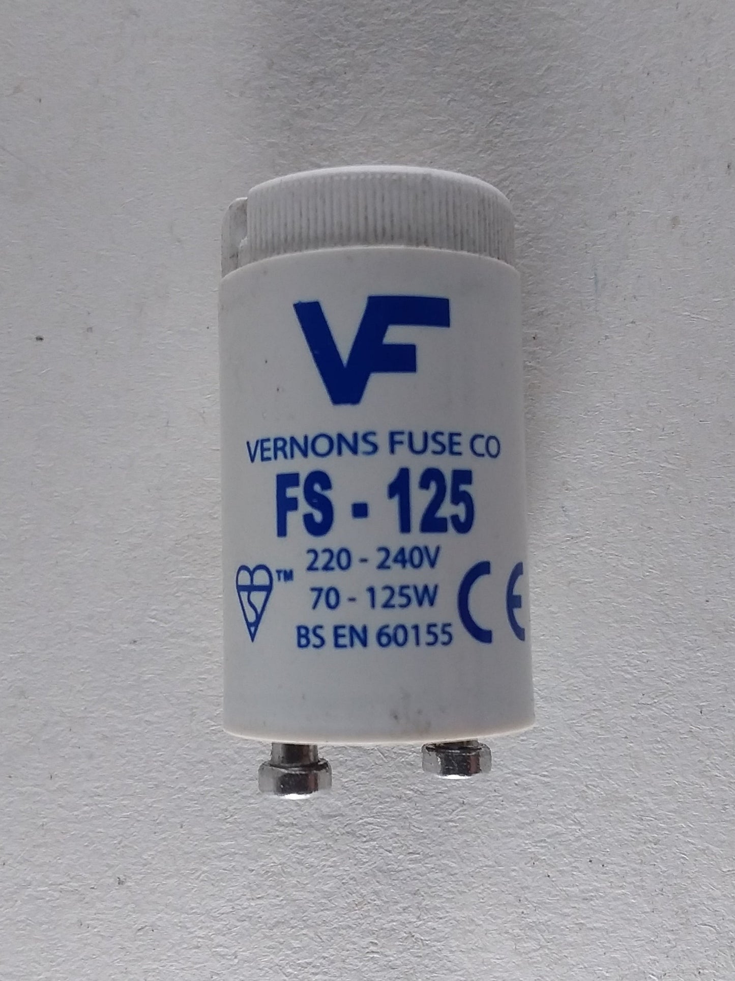 A white lamp starter with the branding 'Vulcan Fluorescent F-125' on it.