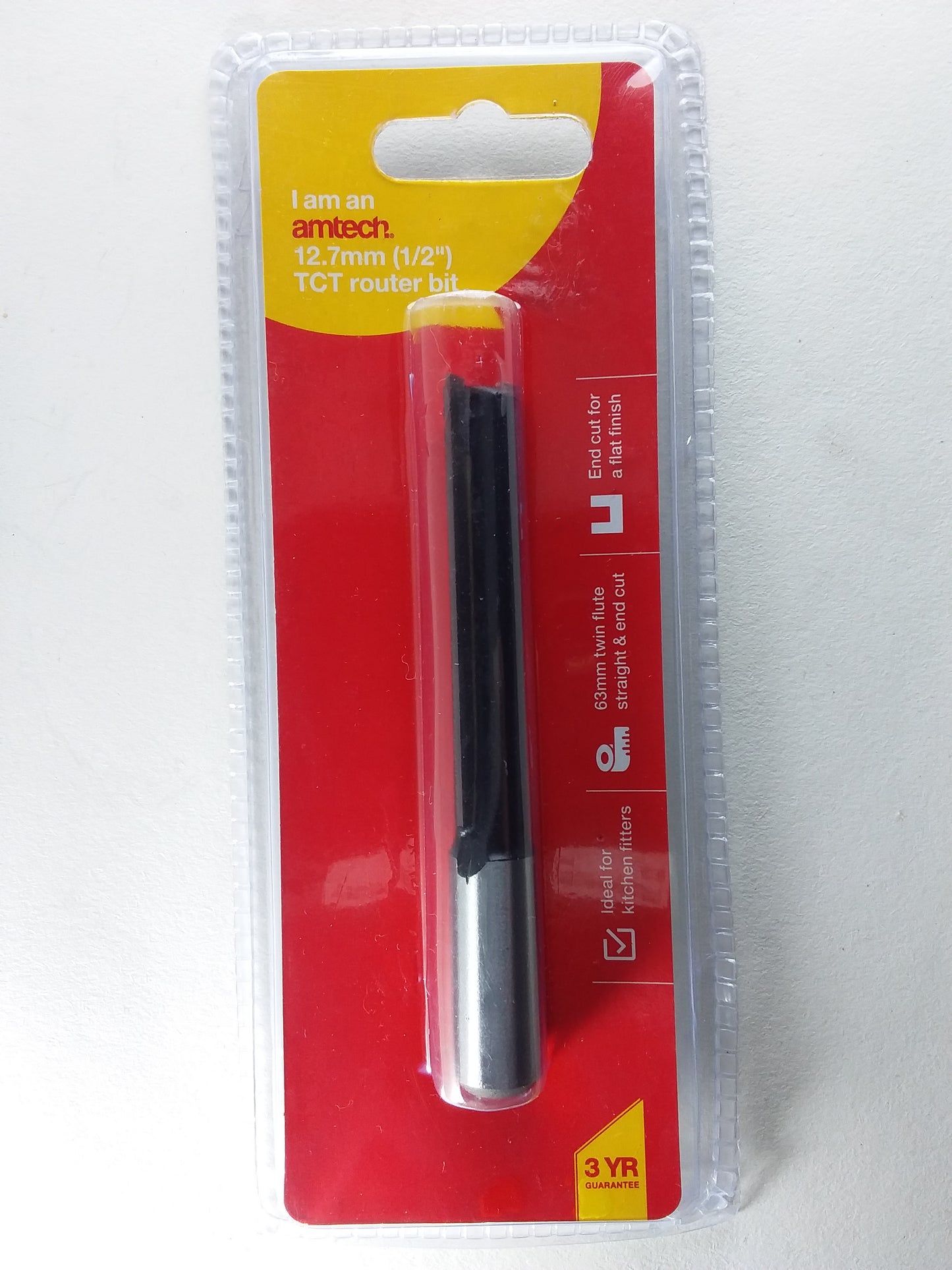 A 1/2" router bit with a red and yellow label, predominantly black in color.