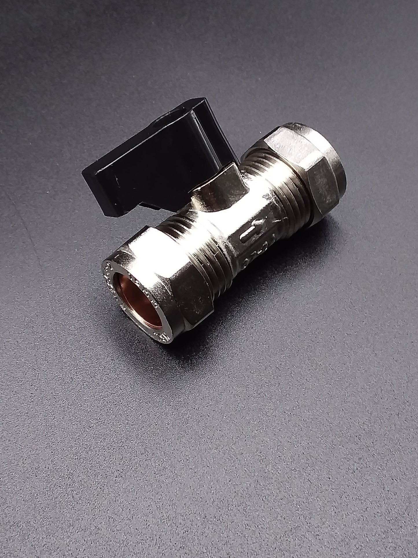 A 15mm silver-colored isolating valve with a black handle on top.