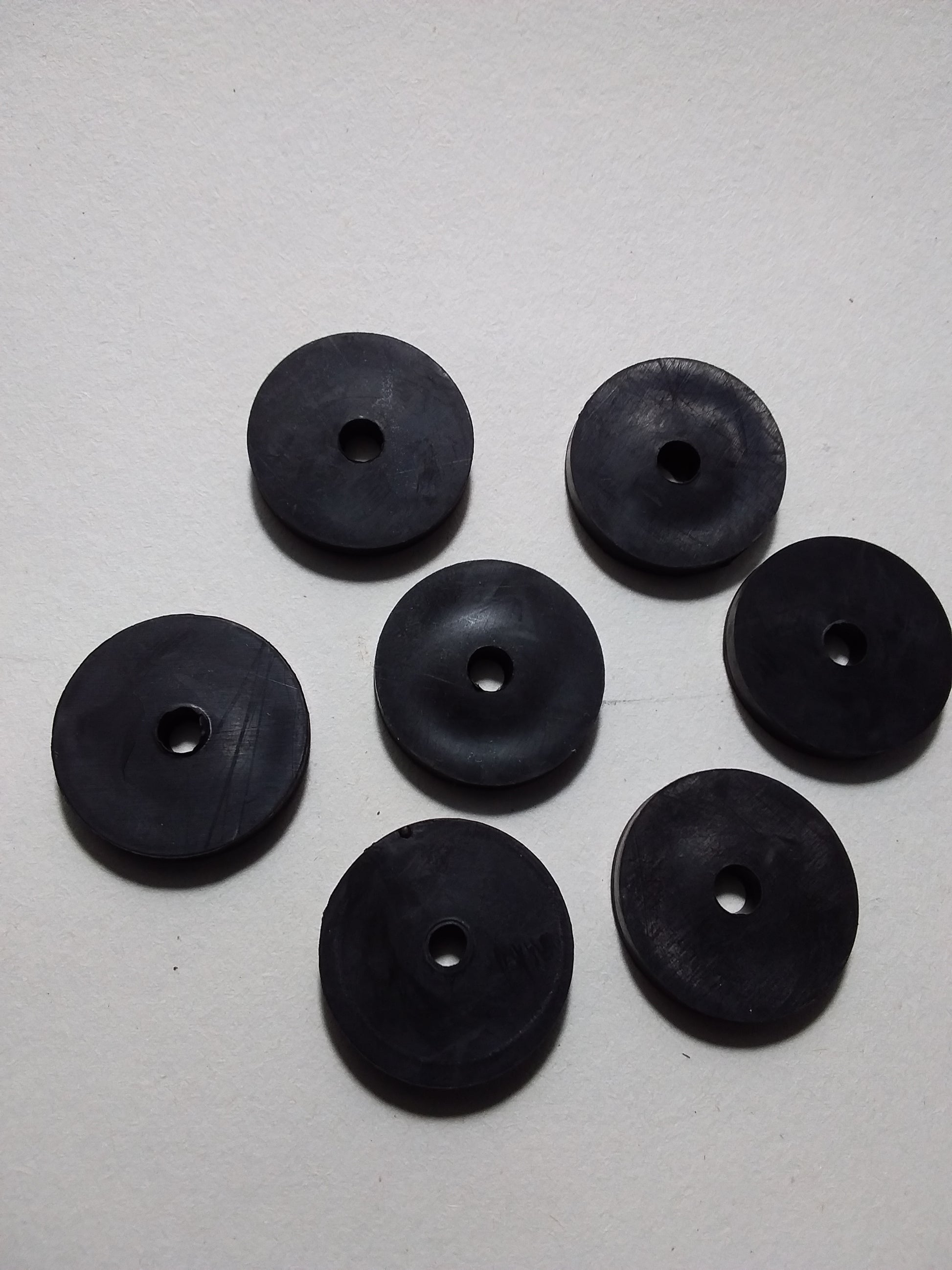 1/2" black rubber tap washers arranged on a surface.