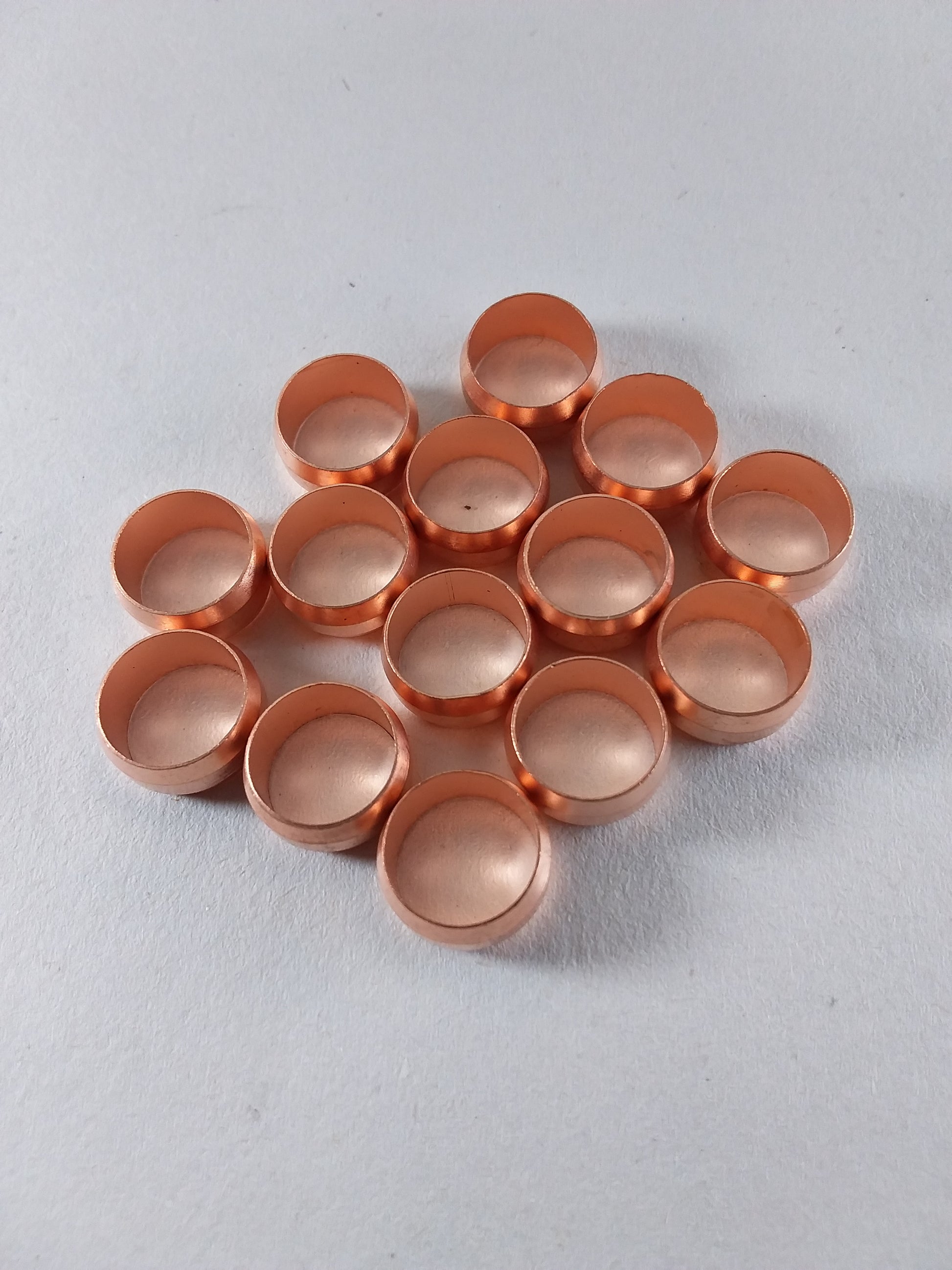 Copper colored olive shaped plumbing fittings.