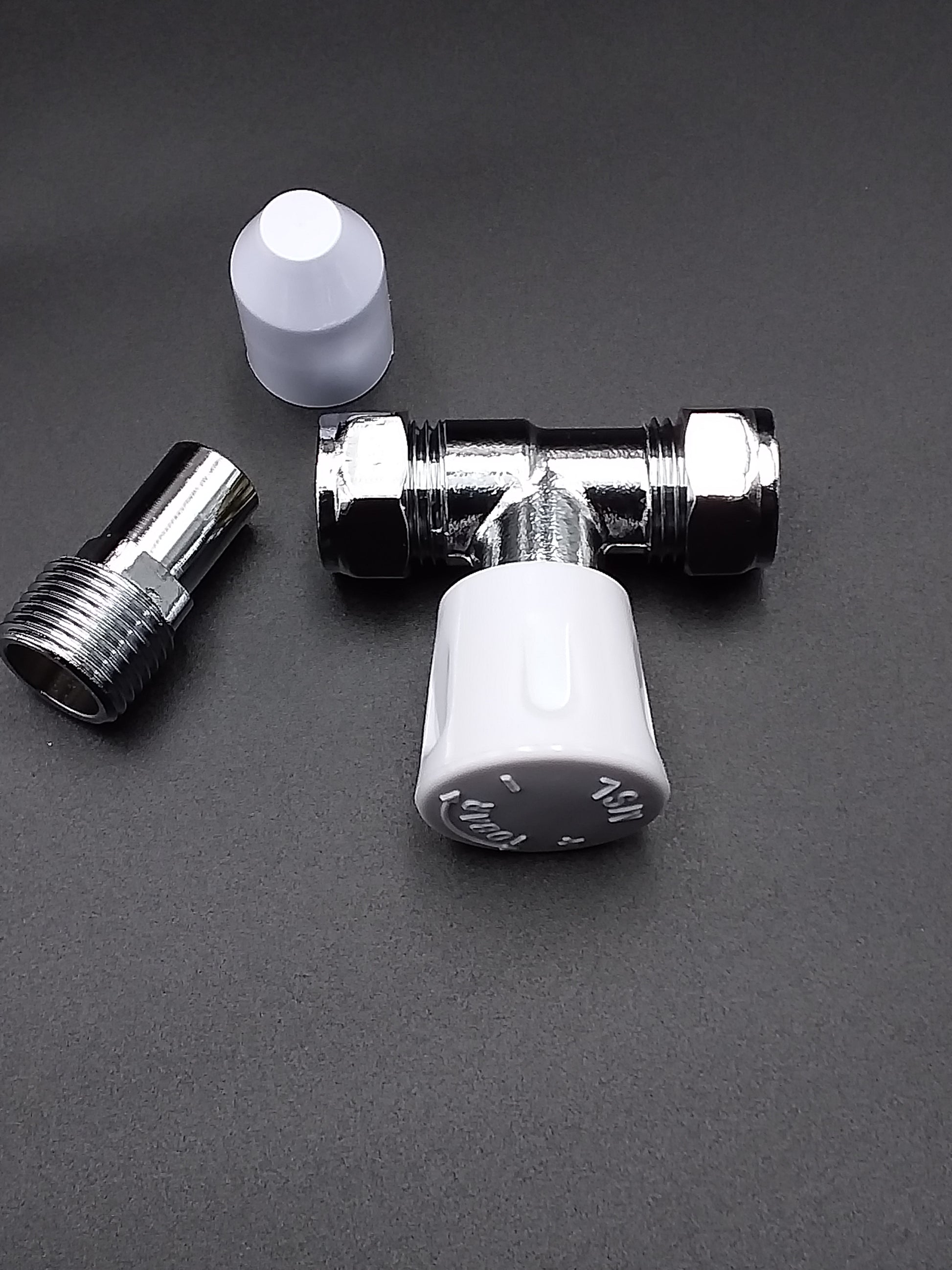 A 15mm L/S radiator valve with a straight design, featuring a metallic body and a white plastic handle.