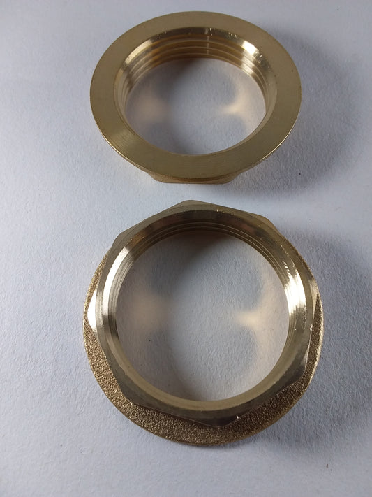 Brass plumbin waste back nuts, one with a threaded interior and the other with a smooth exterior surface.