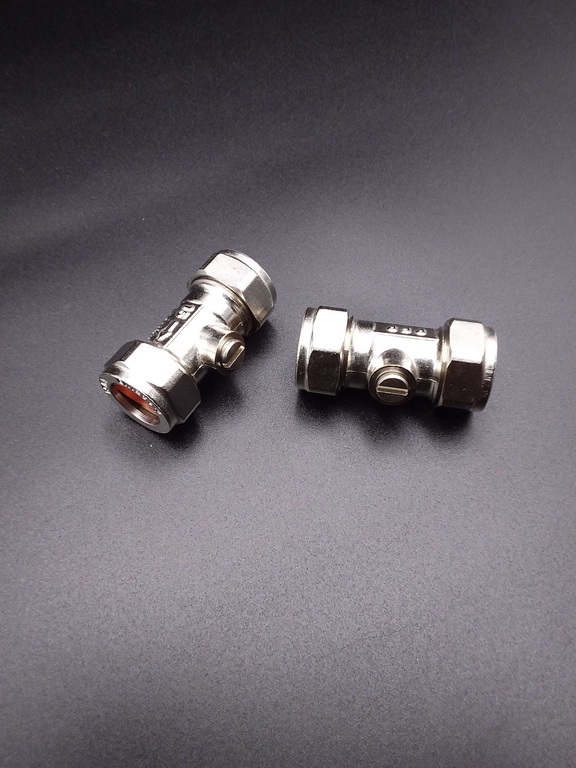 Two 22mm metal isolating valves are shown against a dark background. They are silver in color and have threaded connections for installation.